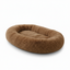 Plush brown oval dog bed with fluffy, soft fabric on a white background.