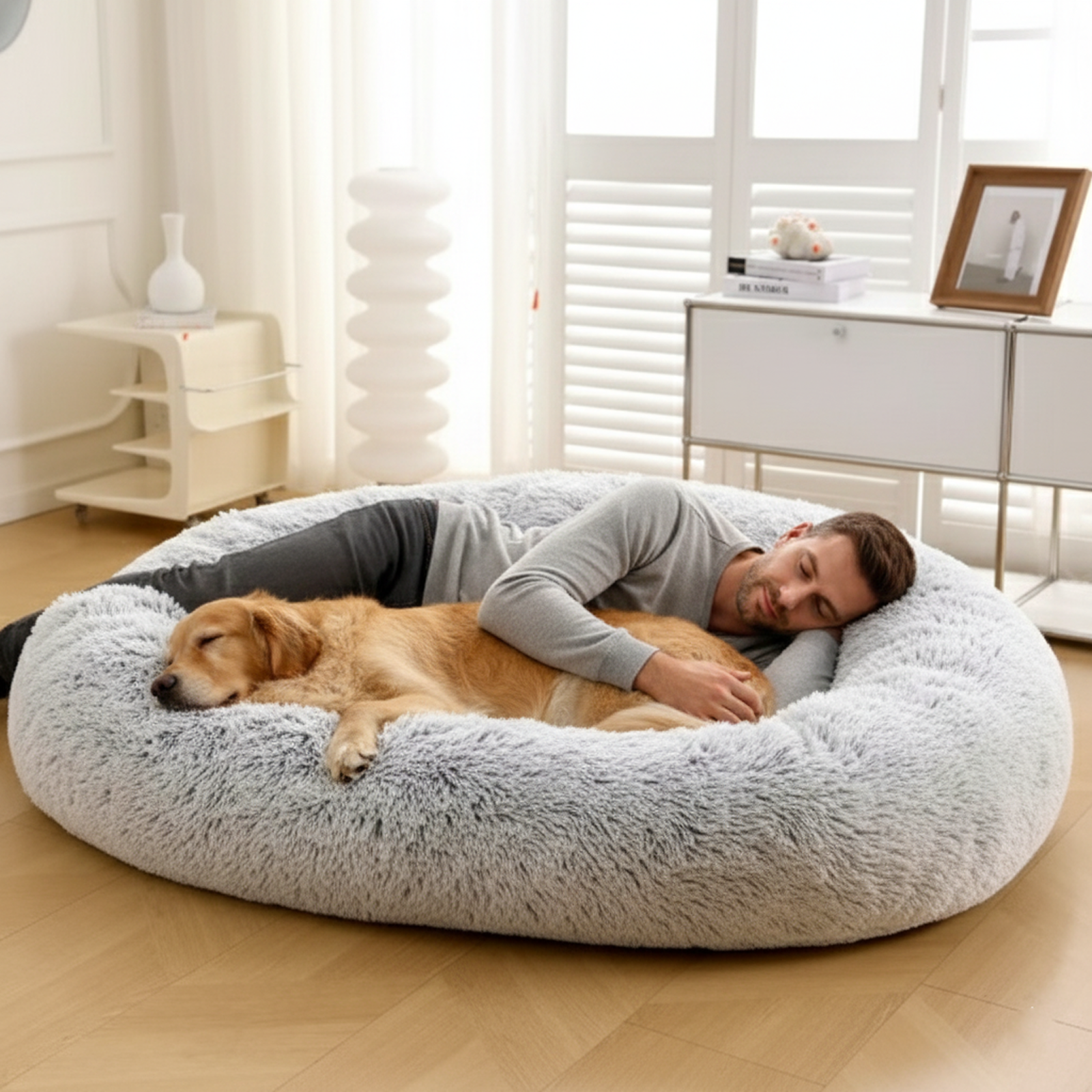 Man and golden retriever cuddling on large fluffy pet bed in bright modern living room