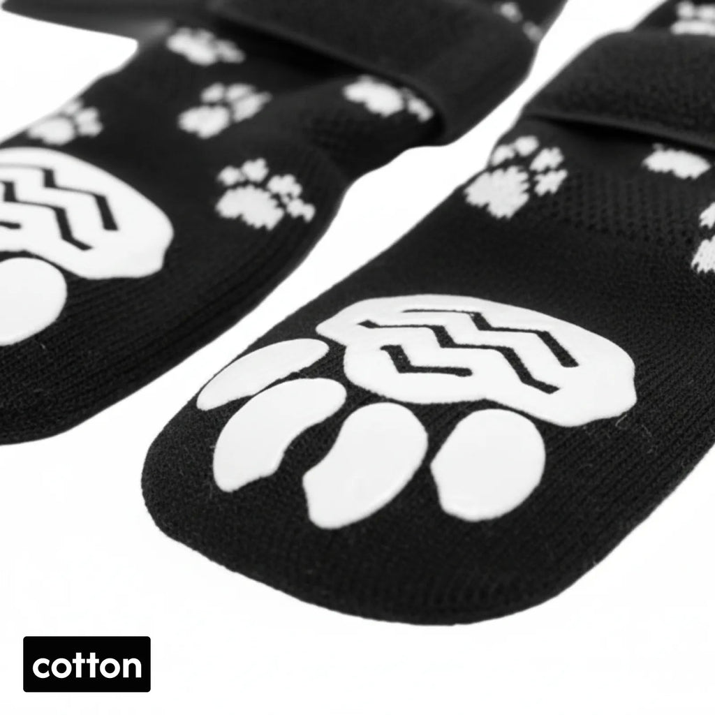 Black cotton pet socks with white paw print grips and adjustable straps for dogs or cats