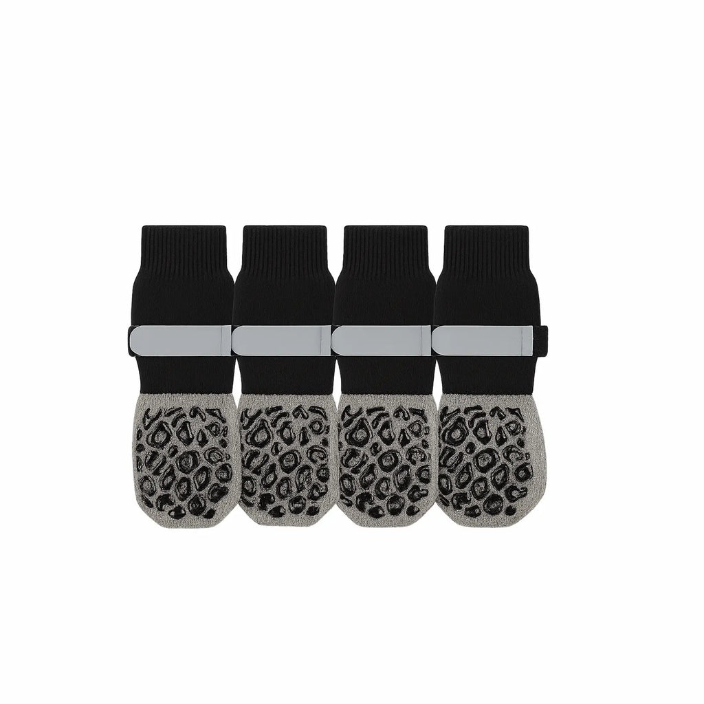 Set of four black and gray non-slip pet socks with paw grip pattern and reflective straps.