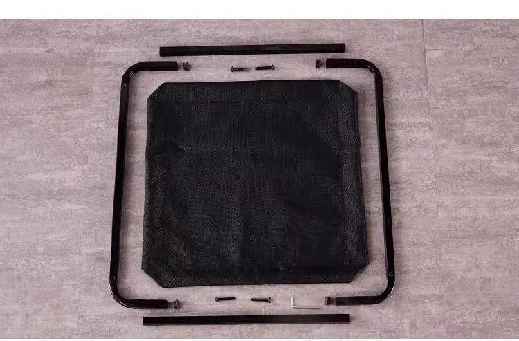Disassembled elevated pet bed frame with mesh fabric and assembly hardware on gray floor