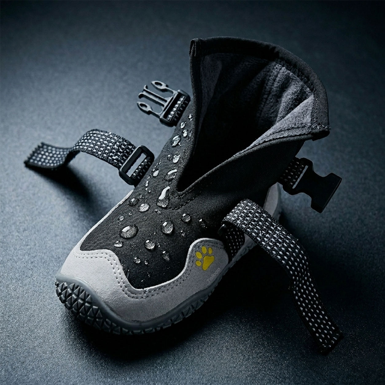 Tailooo dog boot with wide opening and dual adjustable straps and quick-release buckle shown open, demonstrating easy on and off design with water droplets on the waterproof surface.