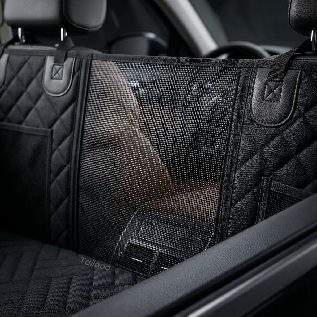 Black dog car seat cover with transparent mesh pet barrier installed between front and rear seats in an SUV, showing a dog visible through the mesh partition.
