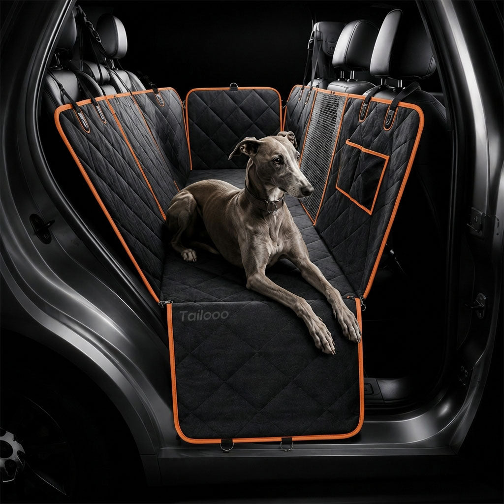 A greyhound relaxing on a black quilted dog car seat cover inside an SUV rear seat, showing full coverage and comfortable fit.