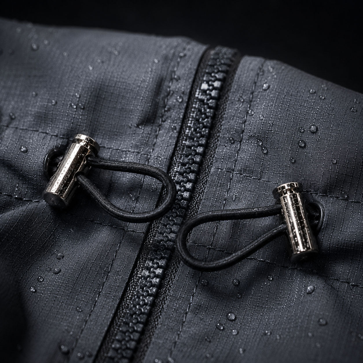 Close-up of elastic drawstring cord and metal toggles on a waterproof dog jacket, showing adjustable waist fit for different dog body shapes.