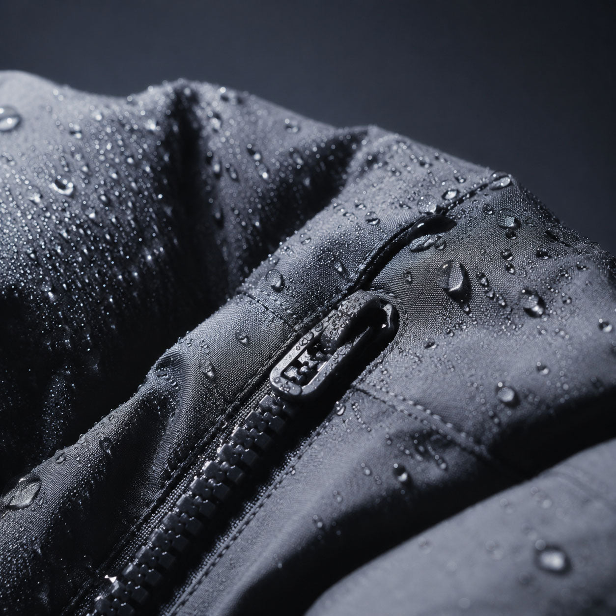 Close-up of a waterproof dog jacket covered in rain droplets, showing the waterproof zipper and water-resistant outer shell fabric.