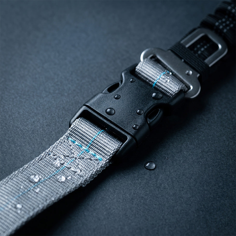 Close-up of a grey dog leash buckle with water droplets on 1680D nylon webbing, showing durable waterproof construction.