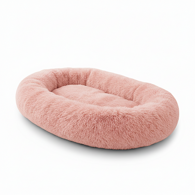 Plush pink oval pet bed with fluffy texture on a white background Hover Image