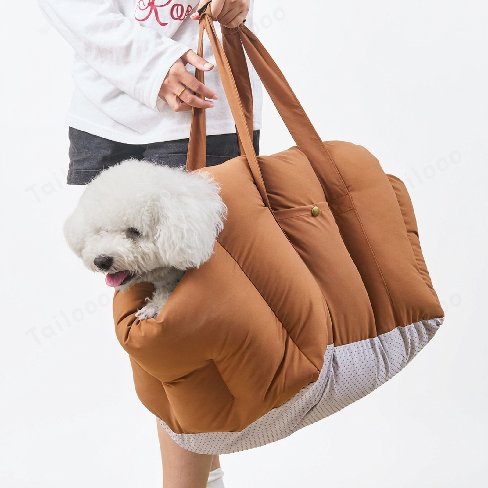 A woman carrying the portable dog car seat as a shoulder bag, with a cute puppy relaxed inside, walking along a scenic coastal path, highlighting its versatility.