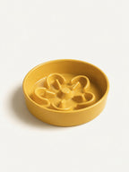 Isolated yellow ceramic slow feeder dog bowl, durable and easy-to-clean dog bowl for slow feeding.